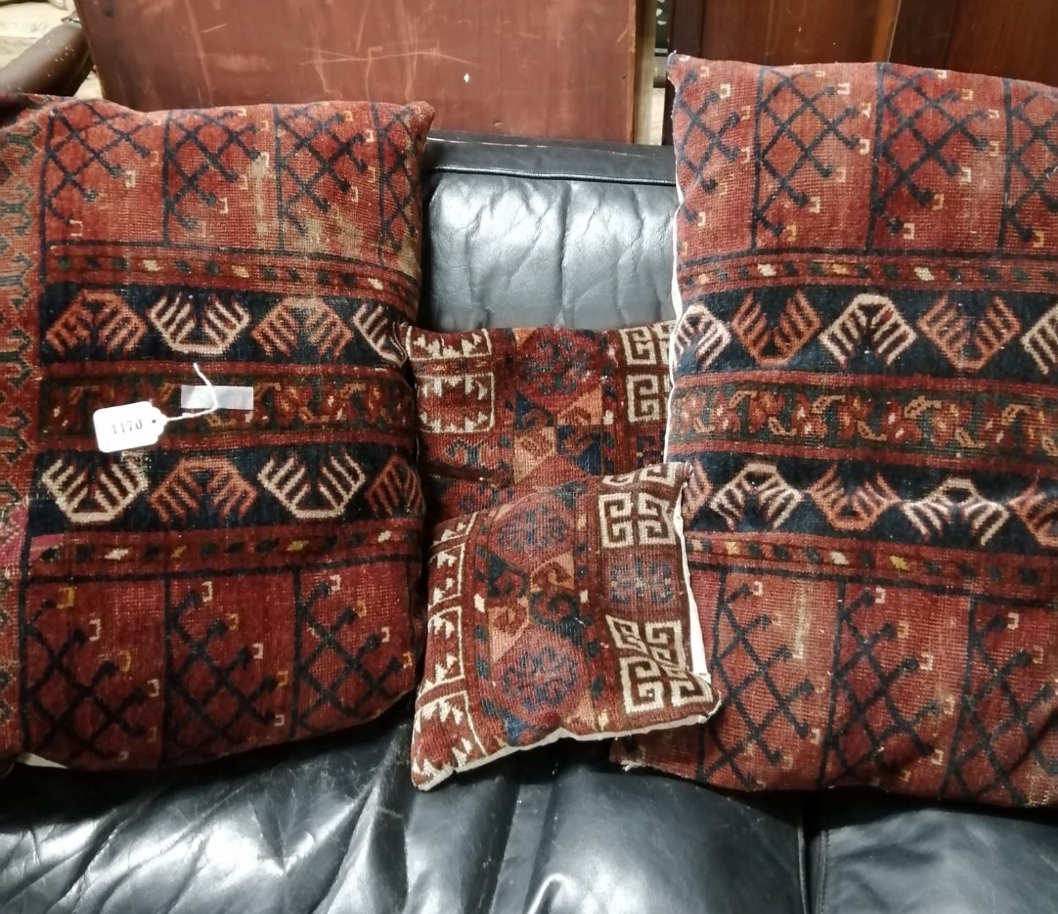 Four Tekke / Bokhara carpet cushions in two sizes larger 70cms x 50cms